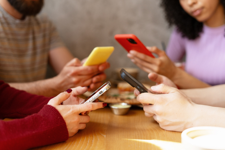 friends-ignoring-each-other-looking-at-their-smartphones-at-restaurant-table